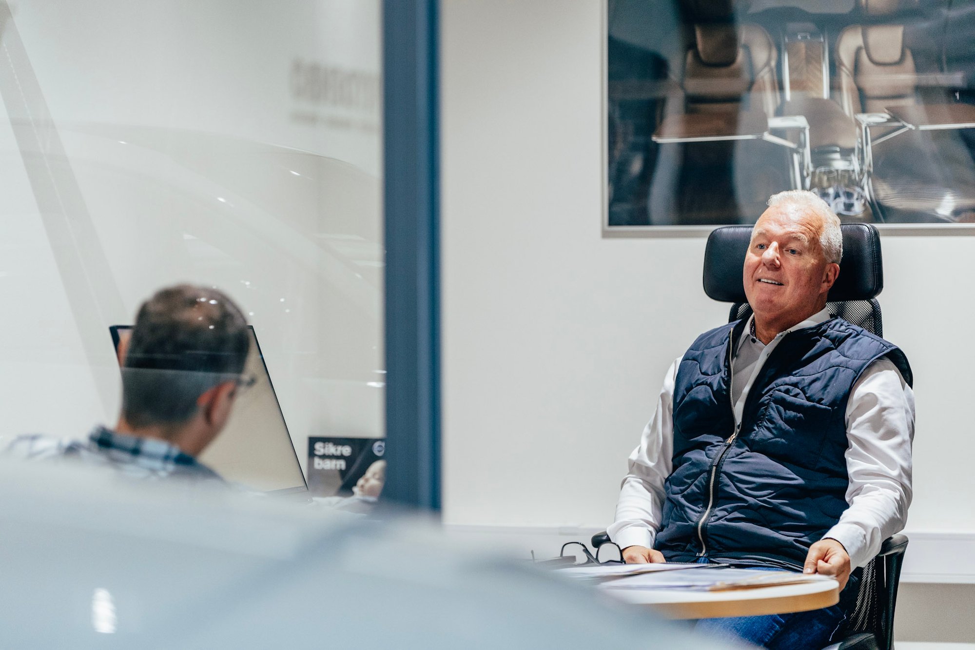 En selger sitter på sitt kontor og snakker med en kunde