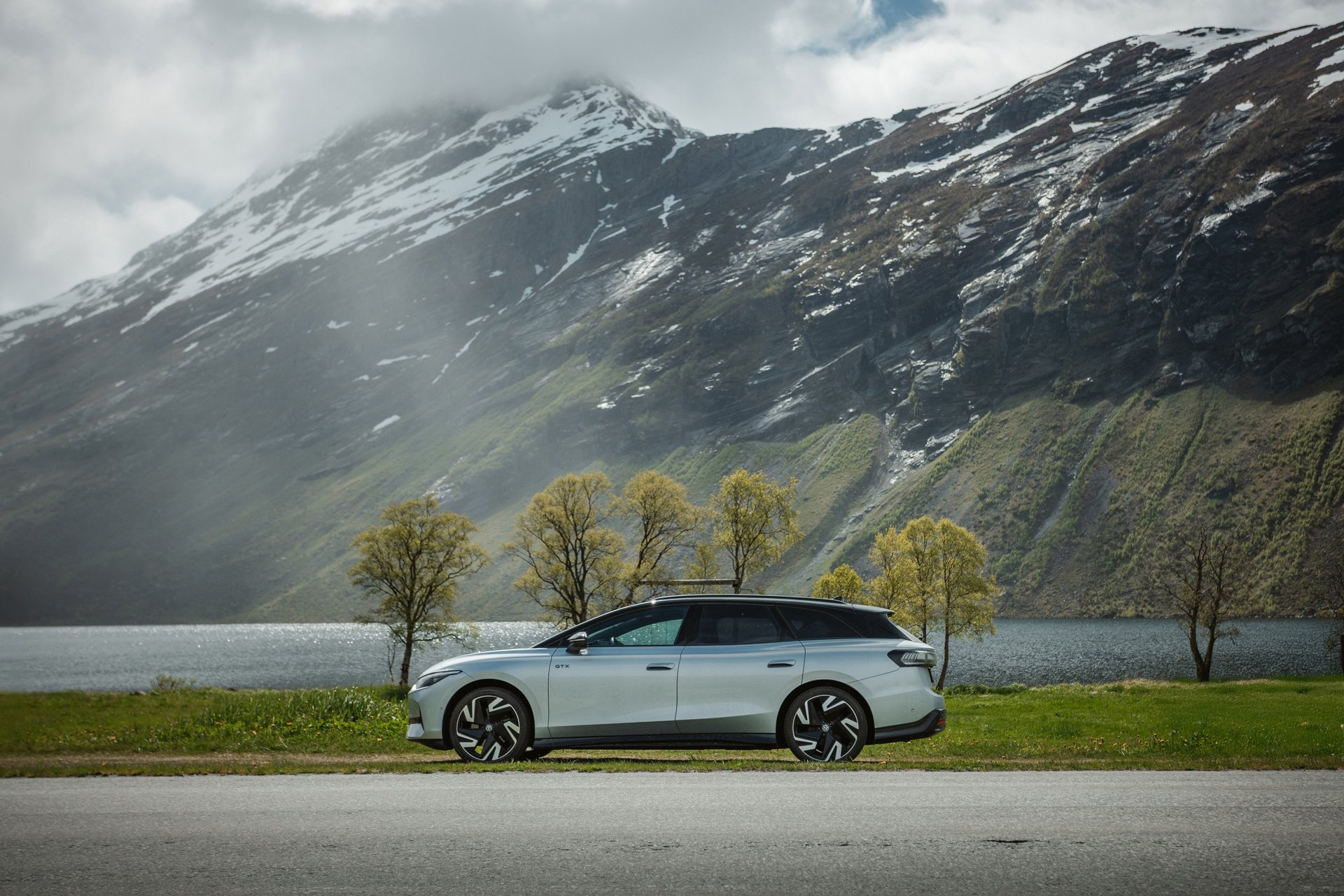 Volkswagen ID.7 sett fra siden med fjord og fjell i bakgrunnen