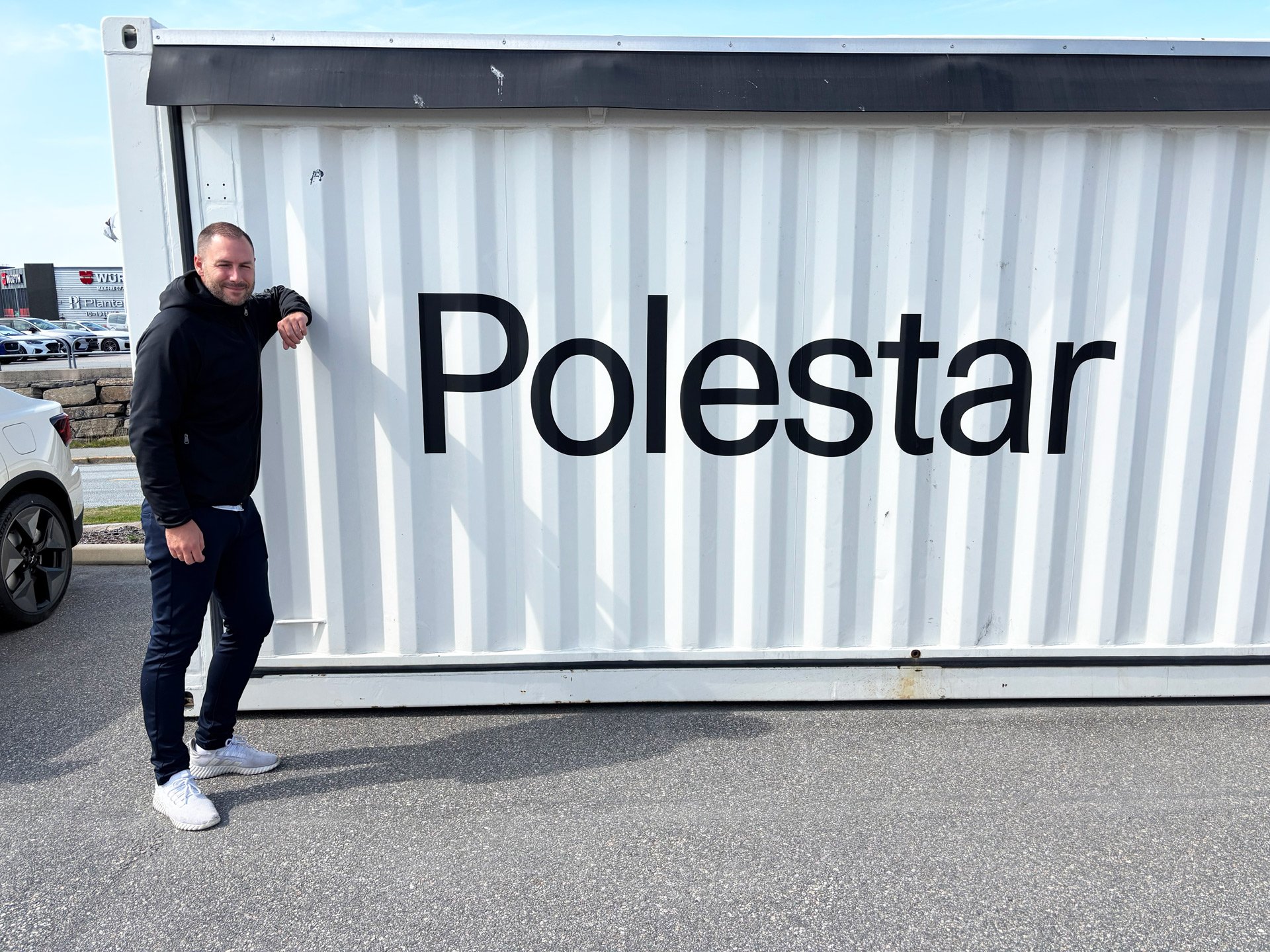 En Polestar ansatt står inntil en hvit container med Polestar skrevet på