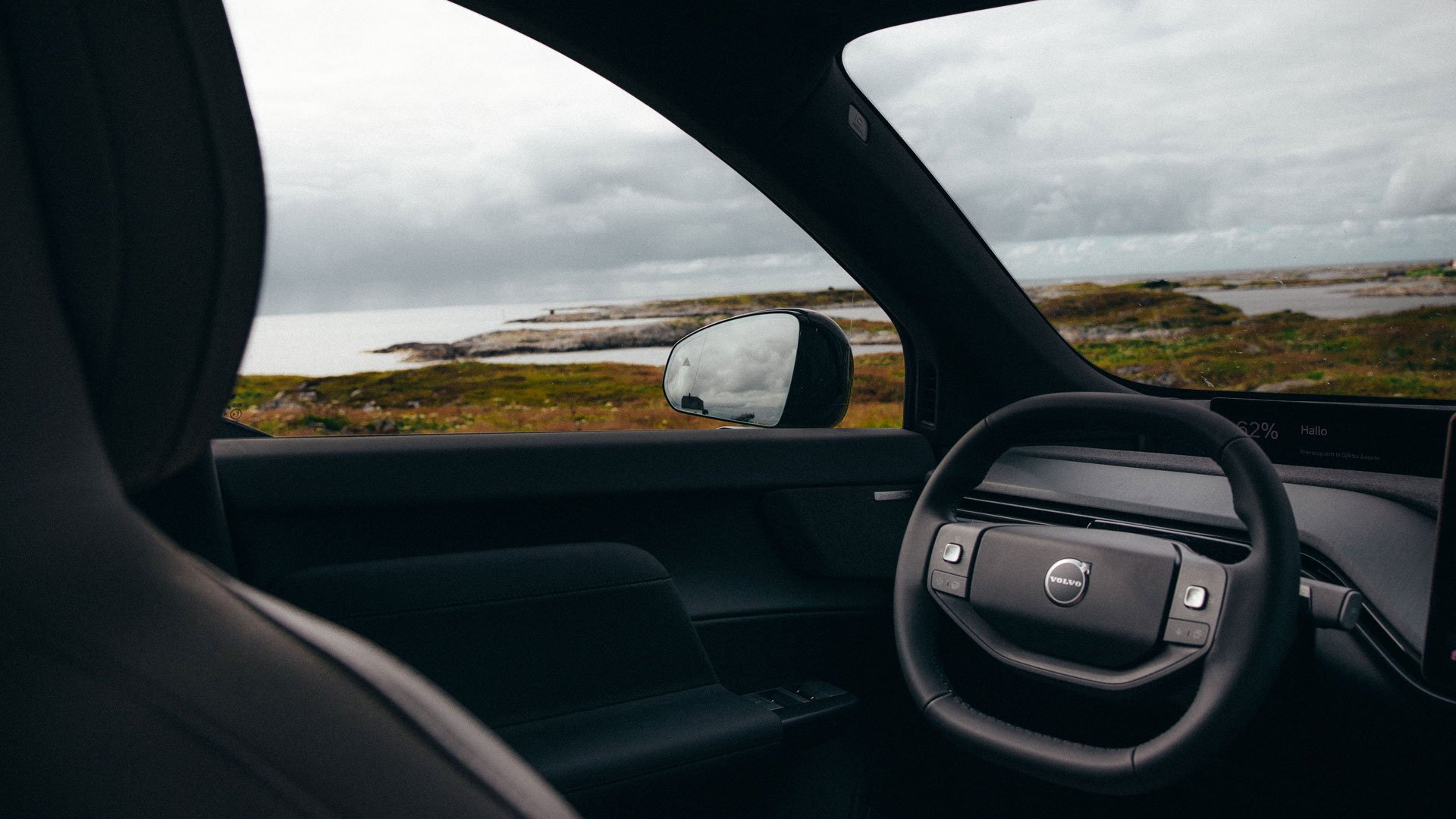 Interiøret i en Volvo EX60 med flott norsk kystnatur utenfor