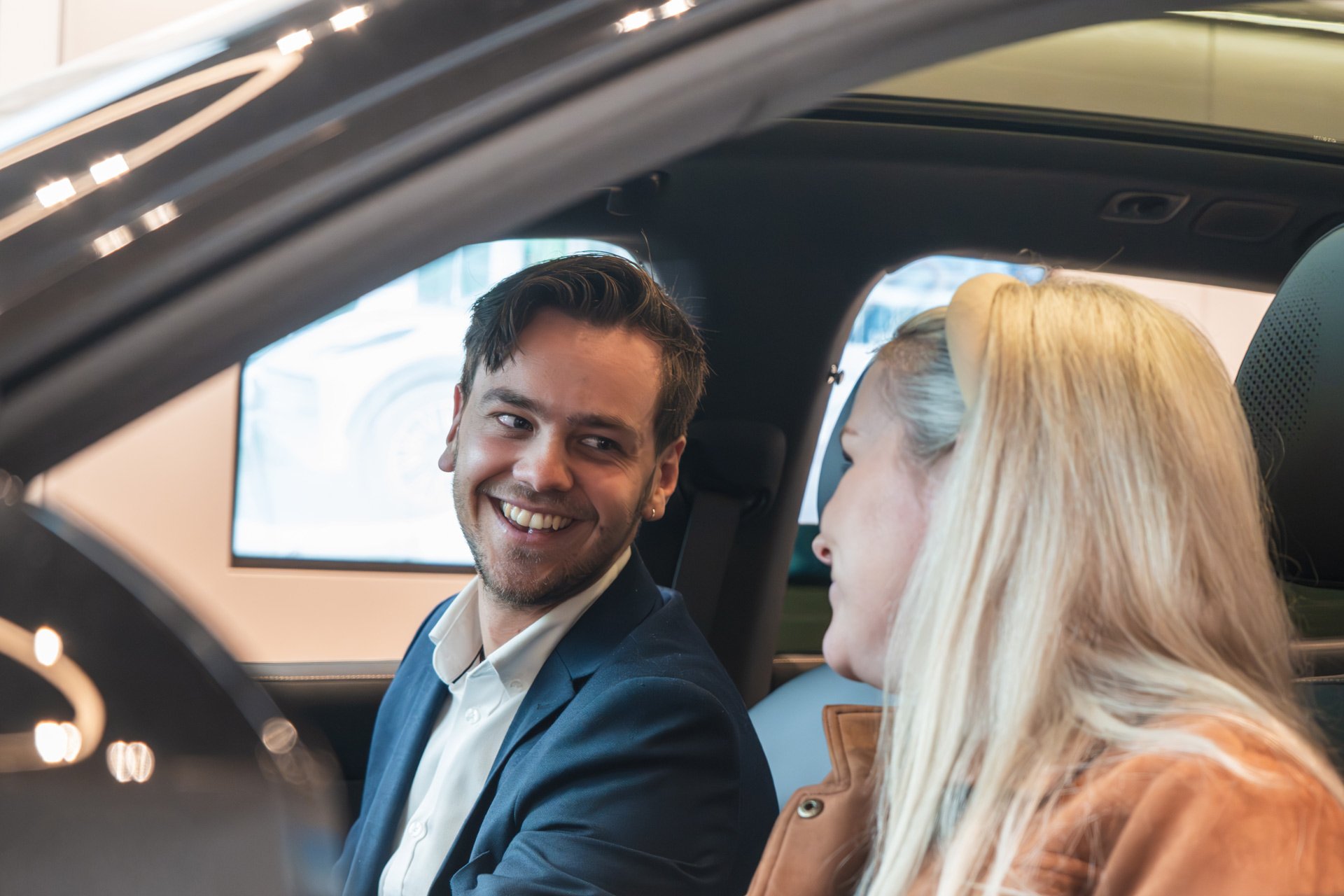 en smilende selger og kunde i en Zeekr 7X