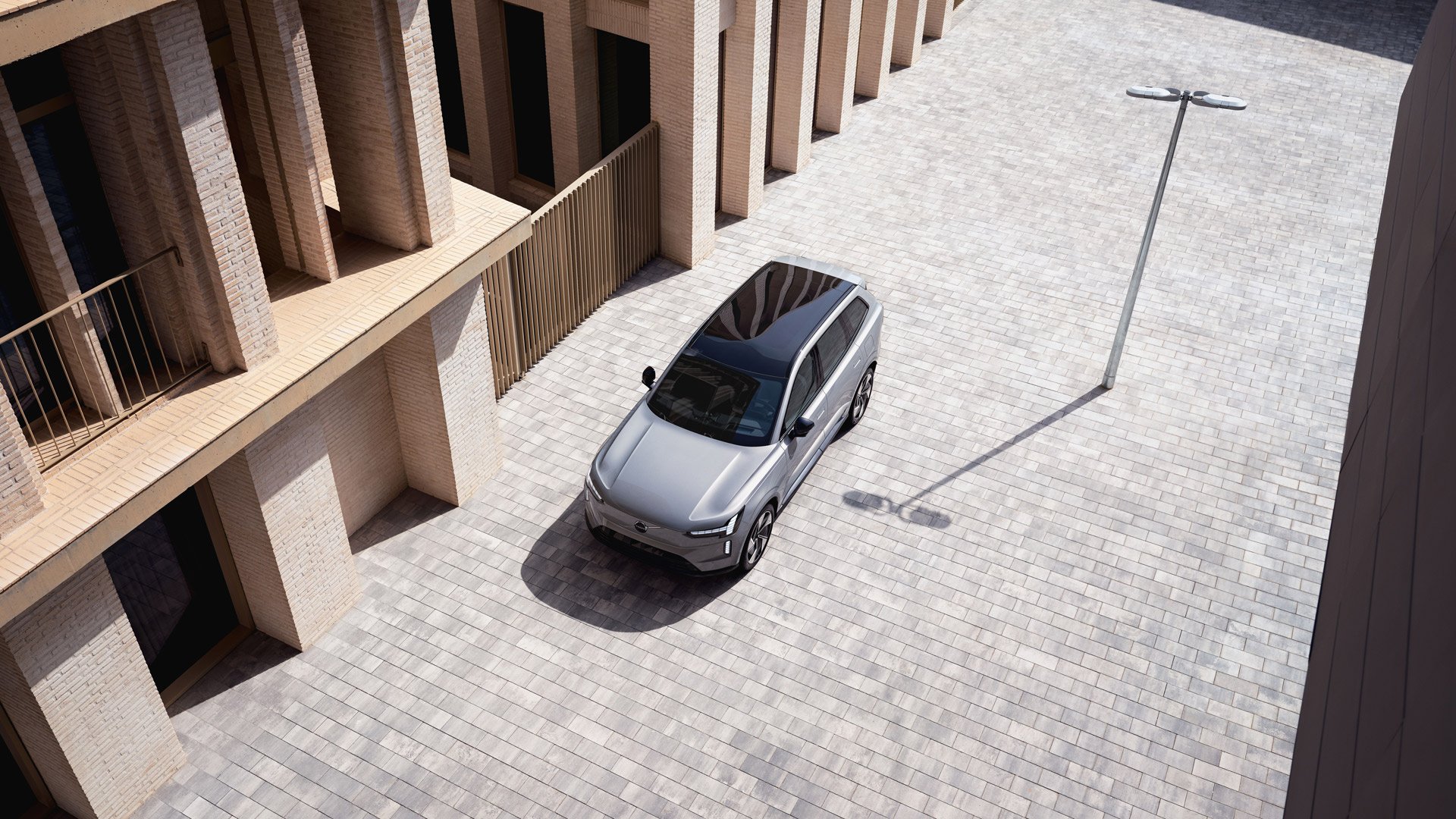 Volvo EX90 sett skrått ovenfra på en brosteinbelagt gate