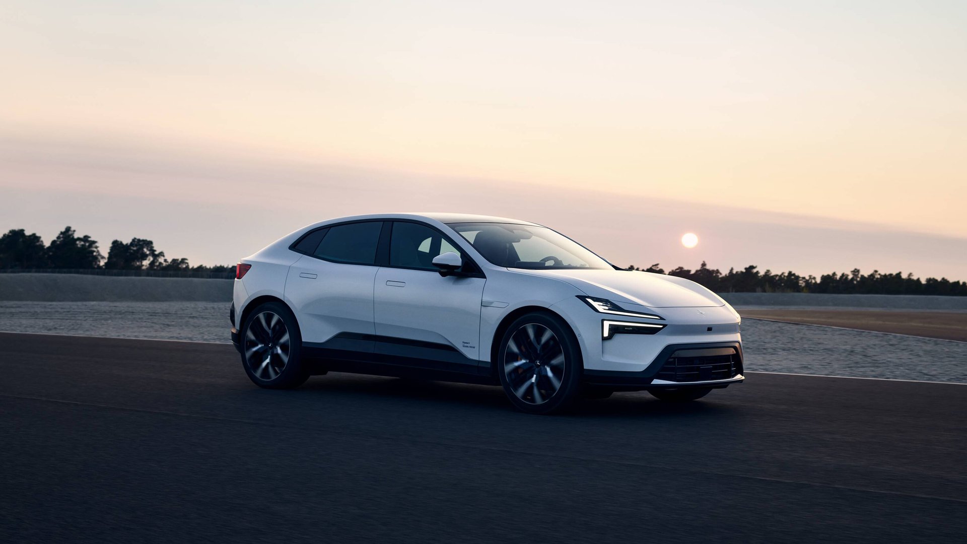 Polestar 4 parkert på en racingbane med solnedgangen i bakgrunnen
