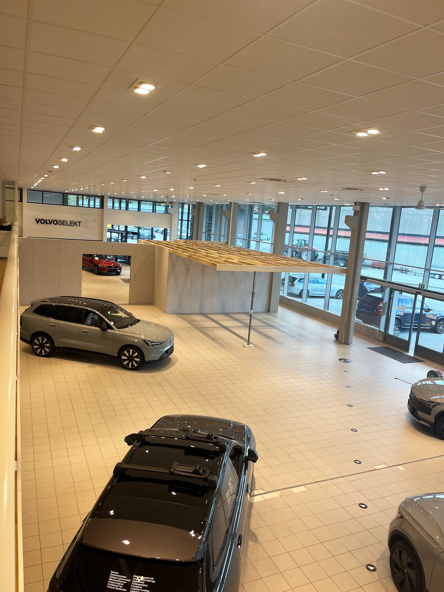 Ombygging av Frydenbø Bil Førde, sett fra butikken hvor nye vegger settes opp i en bilhall med biler utstilt