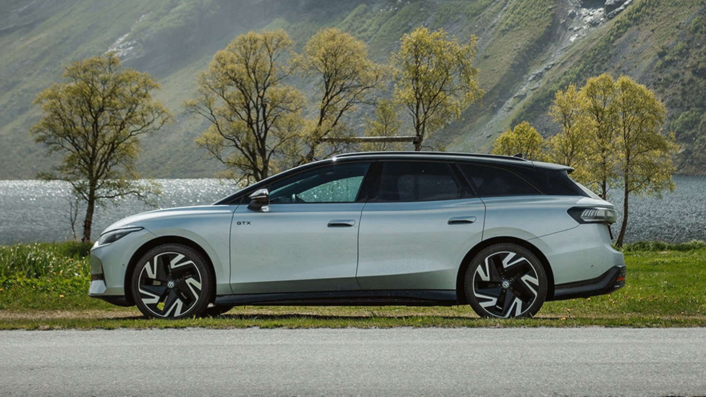 Volkswagen ID.7. En sølvfarget bil parkert langs en innsjø. Det er flott vær.