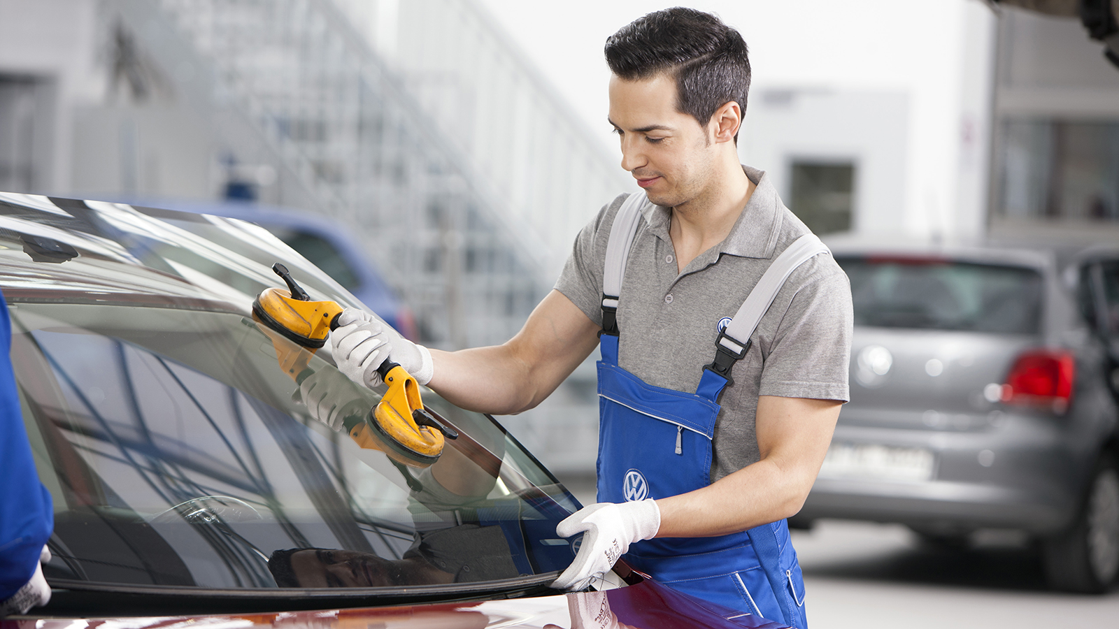 Frontruteskift. Mann som skifte frontrute på en Volkswagen