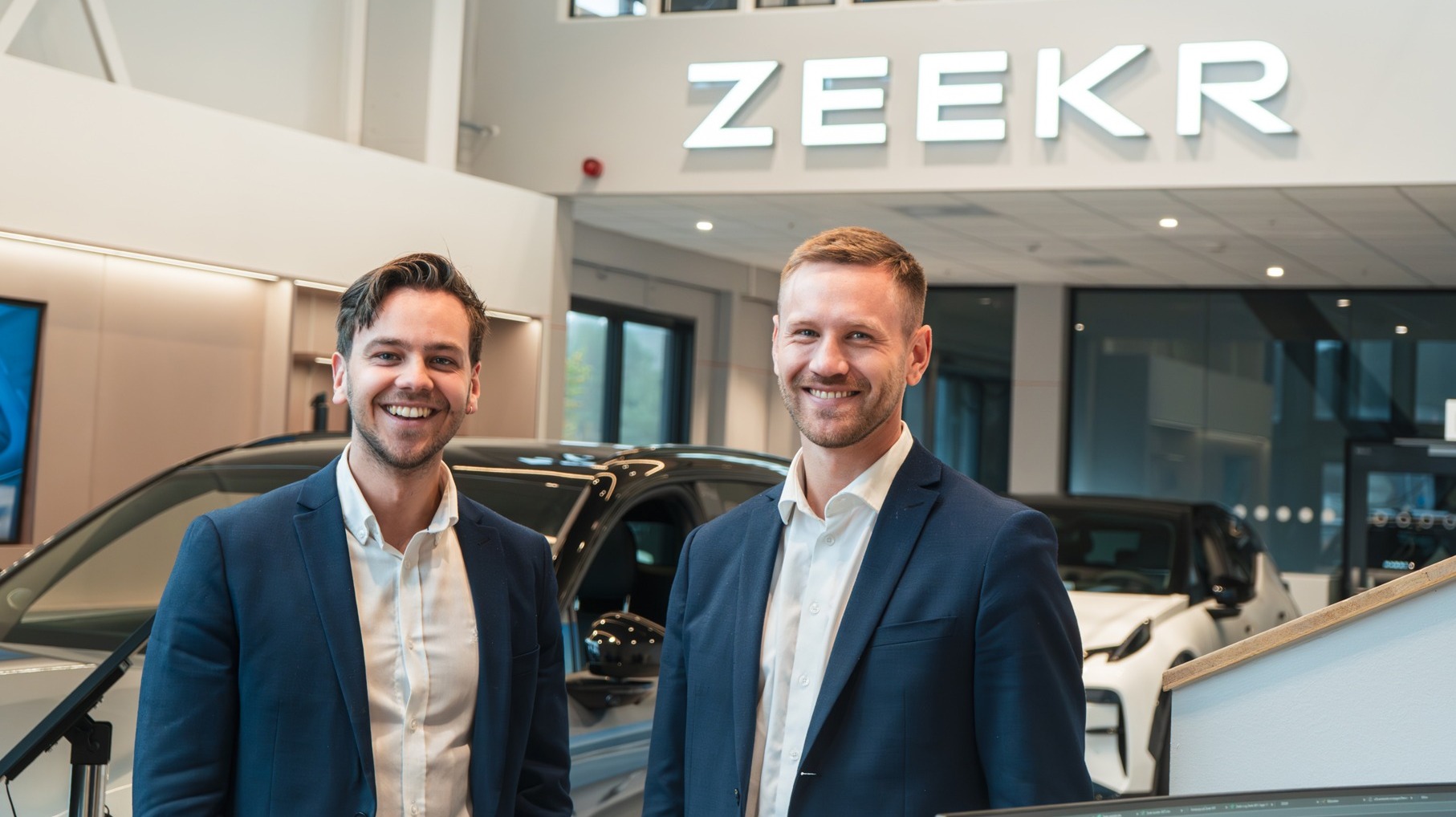To smilende ansatte i butikken hos Zeekr Bergen