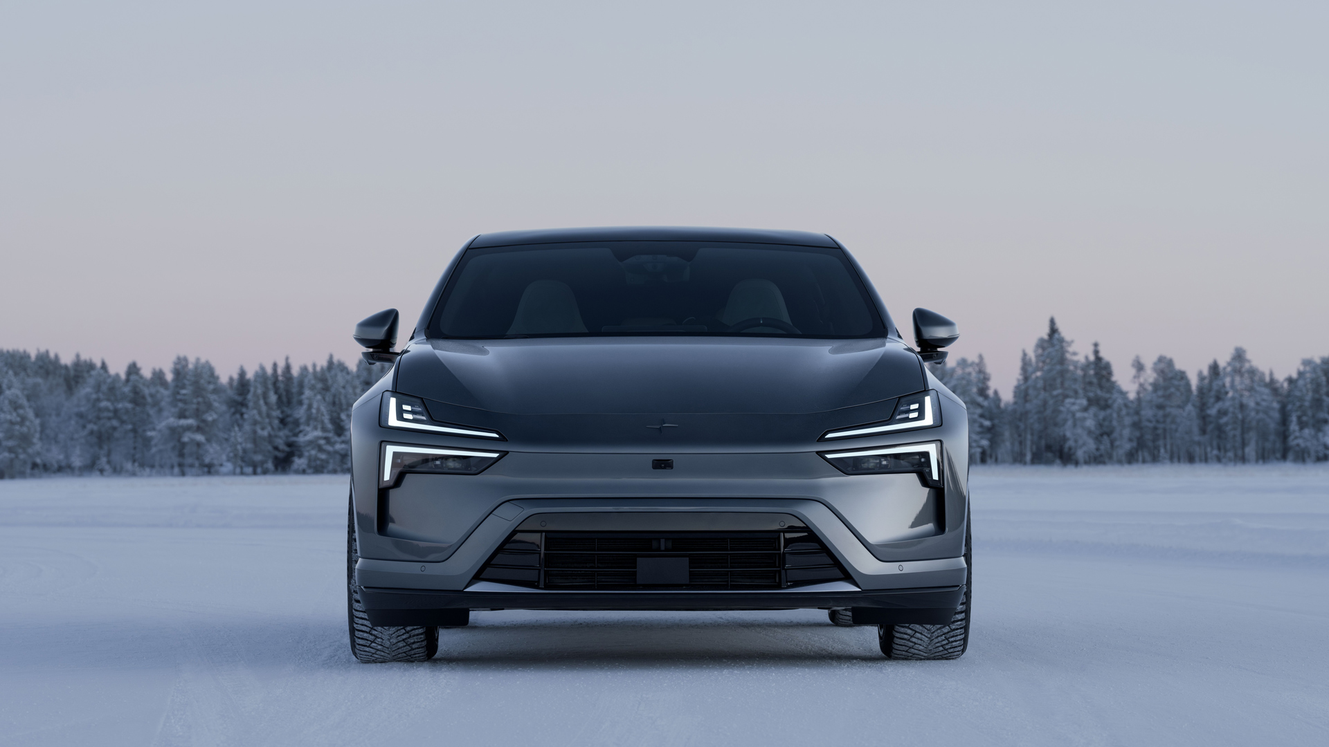 En Polestar 4 sett forfra stående parkert på snøen med natur bak